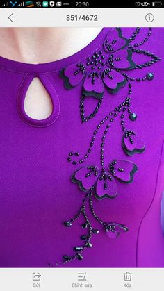 a woman wearing a purple dress with black beading on the neck and shoulderline