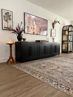 a living room with a large rug and pictures on the wall