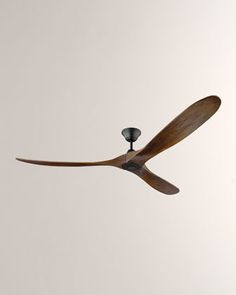 a ceiling fan in the shape of a propeller on a white wall with a black light