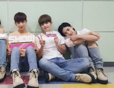 four young men sitting on the floor with their arms around each other