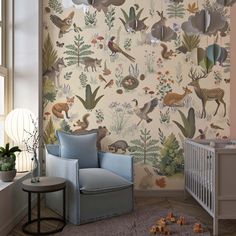 a baby's room with a crib, rocking chair and wallpaper design