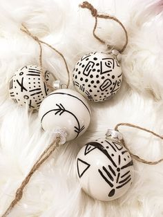 three ornaments with black and white designs on them sitting on a fur covered floor next to each other