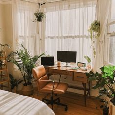 a bedroom with a desk, chair and computer on it in front of a window