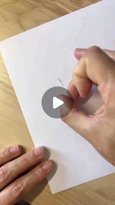 someone is cutting out a piece of paper with scissors