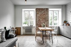 a living room filled with furniture and a brick wall