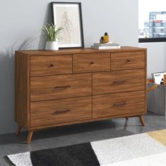 a wooden dresser sitting on top of a carpeted floor next to a white wall