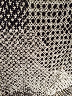 an intricate knitted fabric with circles and dots on the side, in black and white