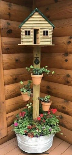 a bird house with potted plants in it