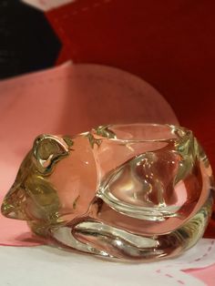 a glass animal figurine sitting on top of a pink and white tablecloth