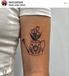 a black and white tattoo of a teapot with tulips on the arm