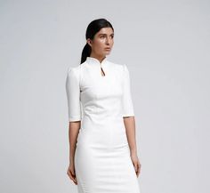 "A modern qipao dress featuring a fitted sheath silhouette, midi length and a high neck collar. - modern cheongsam style - keyhole mandarin neck with fabric button - fitted pencil silhouette - knee length (midi) - 2/3 puffy sleeves  - french darts - сoncealed back zipper closure - lined bodice Color: milky white Fiber: viscose - 40%, elastane - 5%, polyester - 55% Lining: viscose - 95 %, elastane - 5% For Size 02 US / 36 EU: dress length - 40\"(102 cm), sleeve length - 14,5\" (37 cm) Our model w Modern Qipao Dress, White Cheongsam, Mandarin Dress, Scooter Dress, Long Wrap Dress, Black Collared Dress, Modern Qipao, New Look Fashion, High Neck Collar