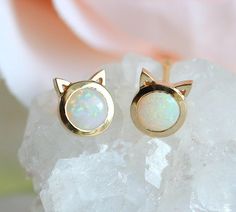 A pair in 14K YELLOW gold is already made and ready to be shipped. Cute opal cat stud earrings. A perfect gift for your girls; daughter, girlfriend or as a baby baptism gift. These studs are available in 14k/18k rose/white/yellow gold. Please select the metal option from the drop-down menu. If you would like to have other gemstones instead of opals please contact us before purchase regarding pricing. Item details: 4mm Australian opal 14k/18k solid gold 6x7mm The earrings will be shipped in a gif Gold Cat Earrings, Cat Earring, Pendulum Earrings, Kitten Earrings, Cat Stud Earrings, Gold Ear Jacket, Little Earrings, Clean Gold Jewelry, Cat Earrings Studs