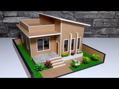 a paper model of a house with flowers in the front yard and steps leading up to it