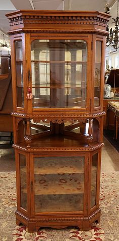 an antique wooden display case with glass doors