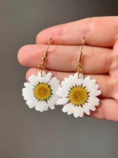 ➡️ [ITEM DESCRIPTION] Real wild white daisy flower, encased in UV resin. Average daisy flower has a 1" diameter. Lightweight, ultra white pedals, the perfect addition to any summer outfit. Earrings come in a variety of closures. See product specs below for more detailed information.  Metal closures and chain available in gold plated and stainless steel. All closures and chains are hypoallergenic and nickel / lead free. ➡️ [AVAILABLE STYLES] *Daisy Earring *Daisy Necklace  --- Custom Orders Accep White Daisy-shaped Jewelry For Spring, White Daisy-shaped Spring Jewelry, White Flower-shaped Jewelry For Birthdays, White Flower Earrings With Summer Decoration, White Flower Earrings With Flower Decoration For Summer, White Summer Flower Earrings, Summer White Flower Earrings With Flower Charm, White Daisy Flower Earrings For Spring, Handmade White Flower Earrings For Spring