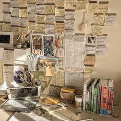 a cluttered desk with lots of papers and books on the wall next to it