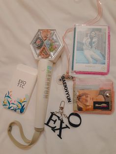 an assortment of personal items are laid out on a bed with tags and keychains