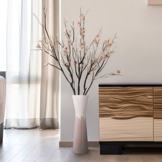 a vase with flowers in it next to a dresser