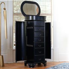 a tall black cabinet with a mirror on top