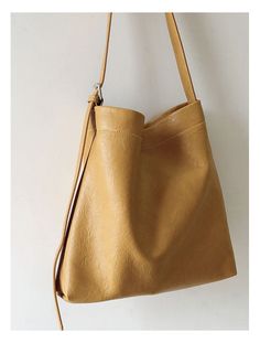 a tan leather purse hanging on the wall