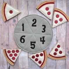 a clock made out of felt with numbers and pizza slices around it on a wooden surface