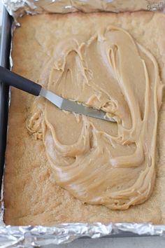 a pan filled with peanut butter frosting next to a knife