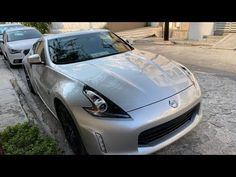 a silver sports car parked next to a curb