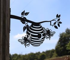 a paper cut out of a beehive hanging from a tree branch with leaves