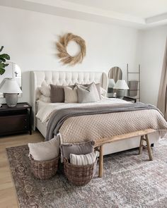 a bedroom with a large bed, two baskets on the floor and a rug in front of it