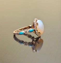 DeKara Designs Collection Metal- 14K Rose Gold, .583. Stones- Center Features an Oval Fiery Australian Opal Cabochon Cut 12 x 10 MM 2.50-3 Carats, Four Marquise Turquoise, 32 Round Diamonds F-G Color VS2 Clarity, 0.50 Carats. Size- 4-12 Beautiful Handmade Art Deco Inspired Turquoise Diamond Halo Opal Engagement Ring Made in 14K Rose Gold. This ring features a beautiful 12 x 10 oval shaped Australian Opal that is professionally set in between four double prongs. The opal is surrounded by 24 round Art Deco Rose, Rose Gold Halo, Deco Rose, Opal Engagement Ring, Opal Engagement, Etsy Wedding Rings, Engagement Rings Opal, Gold Halo, Diamond Wedding Ring