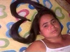 a woman laying on top of a bed with long hair