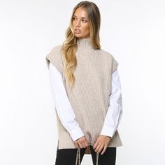 Get A Cool Layered Look This Season With The Ganni Rib Knit Vest. Made Of 70% Certified Recycled Wool To Reduce Waste, Air And Soil Pollution And Generate Lower Co2 Emissions, This Eco-Conscious Piece Is Sustainable As Well As Stylish. This Boxy Knit Features A Mock Neck, Dropped Shoulders And Side Slits, With A Ribbed Knit Design For A Chic Aesthetic. 60% Recycled Wool, 18% Polyamide, 10% Wool, 7% Recycled Polyamide, 5% Other Fibres Side Slits Hand Wash I Am 5'6, 130 Lbs, And Wear A Size Small Cozy Chunky Knit Workwear Tops, Cozy Chunky Knit Tops For Work, Cozy Sweater Vest For Winter Workwear, Beige Chunky Knit Sweater Vest For Fall, Chunky Knit Top For Winter Workwear, Winter Chunky Knit Tops For Work, Chunky Knit Sweater Vest For Winter, Winter Chunky Knit Sweater Vest For Layering, Oversized Winter Sweater Vest With Crew Neck