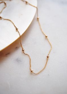 A classic shimmery gold box chain dotted with luminous spheres. This elegant gold chain is a stunning addition to your collection. A striking delicate statement worn alone or with a bevy of other beauties. ✦ DETAILS ✦ ✧ Name: Kahiwa - (kah EE vah) - my favorite. ✧ 1mm chain with 2mm spheres. ✧ 18kt gold filled chain and spring clasp. ✧ All Ke Aloha Jewelry pieces come packaged thoughtfully, beautifully, and ready for gift giving. ✦ MORE GOLD NECKLACES ➤ http://www.etsy.com/shop/kealohajewelry?se Elegant Ball Chain Necklace For Jewelry Making, Gold Plated Ball Chain Necklace Gift, Gold Satellite Chain Necklace As Gift, Ball Chain Necklace With Round Beads As Gift, Gold Beaded Chain Necklace Gift, Gift Chain Necklace With Round Ball Beads, Gold Beaded Chain Necklace As Gift, Gold Jewelry With Delicate Chain And Round Beads, Gold Chain Necklace With Gold Beads For Gift