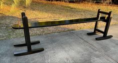 a black bench sitting on top of a sidewalk