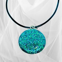 This beautiful circular glitter pendant necklace is crafted with precision using the finest quality resin and glitter, set in a 1-inch round stainless-steel setting, and finished with either a 20" silver-plated chain or a 20" black waxed necklace cord. Its vibrant green hue and sparkly finish will brighten up any outfit and make you stand out from the crowd. Ideal for special occasions. Party Jewelry With Large Round Pendant, Round Large Pendant Jewelry For Party, Glitter Round Jewelry As Gift, Party Necklace With Large Round Pendant, Round Glitter Jewelry As Gift, Round Glitter Jewelry For Gifts, Silver Resin Necklaces For Parties, Resin Jewelry With Glitter For Gift, Glitter Resin Jewelry As A Gift