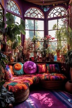 a living room filled with lots of potted plants next to a large open window