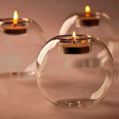 three clear glass vases with candles in them