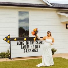 a woman standing in front of a church holding flowers and a sign that says going to the chapel taylor