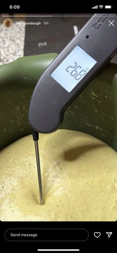 a digital thermometer is being used to measure food in a bowl with yellow liquid