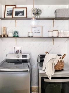 a washer and dryer sitting next to each other in a room with shelves on the wall