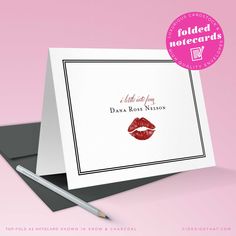 a card with lipstick on it and a pen next to it