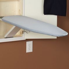 an ironing board mounted to the side of a wall