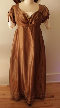 A vintage Regency style dance costume dress, in excellent condition. The material is polyester satin, the lining is linen. The dress is step in style, which closes with pins in front and a waist belt as shown.  The dress fits a modern size 8-10, and measures 37" bust, 32" underbust, waist/hips free, 11" sleeves, 57.5" in length from nape of neck to hem.  *Please note that these items are vintage, and therefore have a history. They may show signs of previous love/wear which will be noted in the l Dance Costumes Dresses, Style Dance, Brown Satin, Formal Gown, Gown Dress, Dance Costume, Polyester Satin, Costume Dress, Formal Gowns