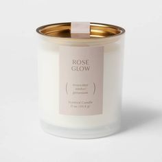 a white candle with a pink label on it