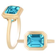 This Blue Topaz Emerald Cut Bezel Set Ring in 18K Yellow Gold is a sleek piece from the 'Manhattan' Collection. It features a stunning emerald-cut Blue Topaz stone set in a 18K yellow gold bezel. This ring embodies modern elegance, offering a touch of luxurious style. Its clean lines and rich hues make it a timeless accessory that effortlessly elevates any look, channeling the chic essence of Manhattan's cosmopolitan vibe. * Gemstone size: 9 x 7 mm * Gemstone: 100% Earth Mined * Approx. gemstone Weight: 2.00 Carats * Cut: Emerald * Metal: 18K Yellow Gold Luxury Timeless Emerald Cut Topaz Ring, Luxury Emerald-cut Topaz Ring Timeless Style, Luxury Timeless Emerald-cut Topaz Ring, Luxury Emerald-cut Yellow Gold Topaz Ring, Luxury Blue Topaz Ring With Bezel Setting, Goshwara Jewelry, Gold Topaz Ring, Prasiolite Ring, London Topaz Ring