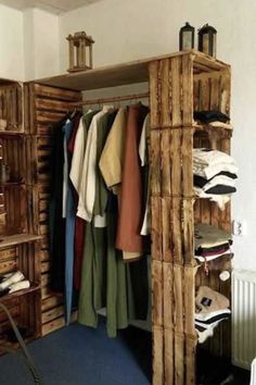 an open closet with clothes hanging on wooden shelves