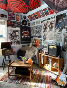 a living room filled with furniture and lots of posters on the wall next to a window