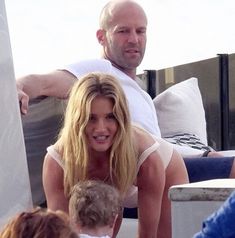 a man and woman sitting next to each other in front of a child on a boat