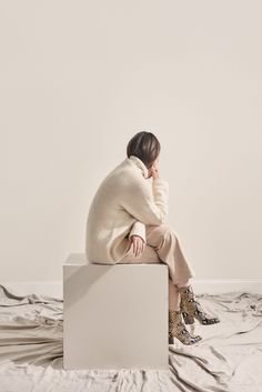 a woman sitting on top of a white box