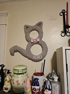 there is a cat decoration on the wall next to other items and decorating utensils